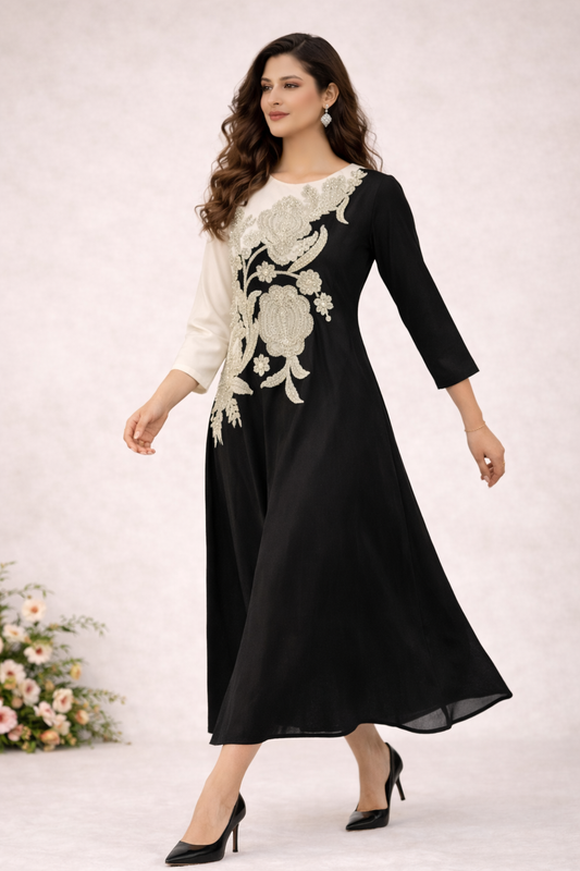 Woman wearing a black dress with white floral embroidery on a white background