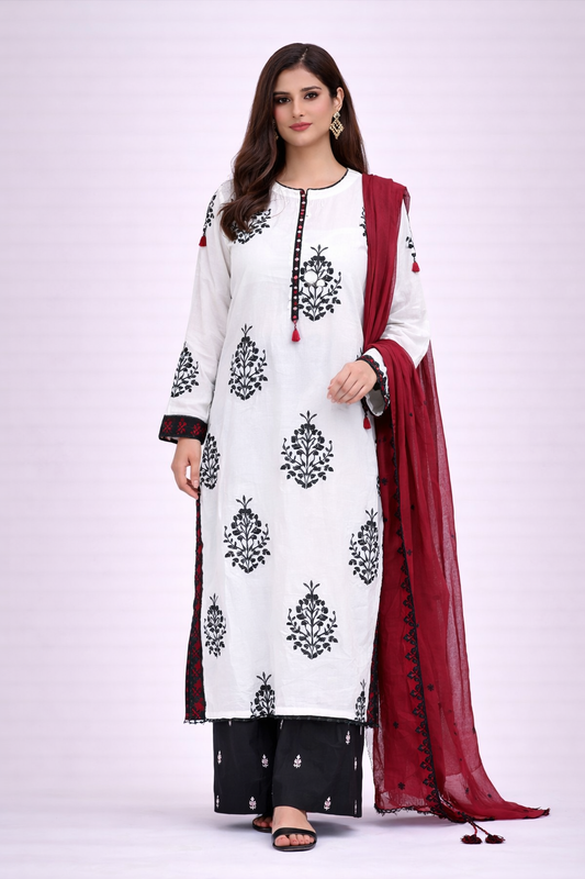 Woman wearing a white and black embroidered outfit with a red dupatta on a white background