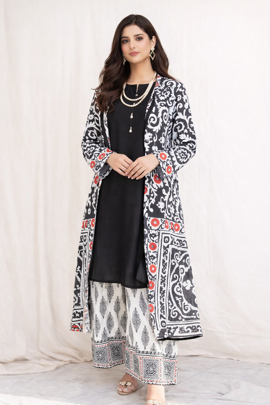 Woman wearing a black and white patterned outfit with a long jacket on a white background