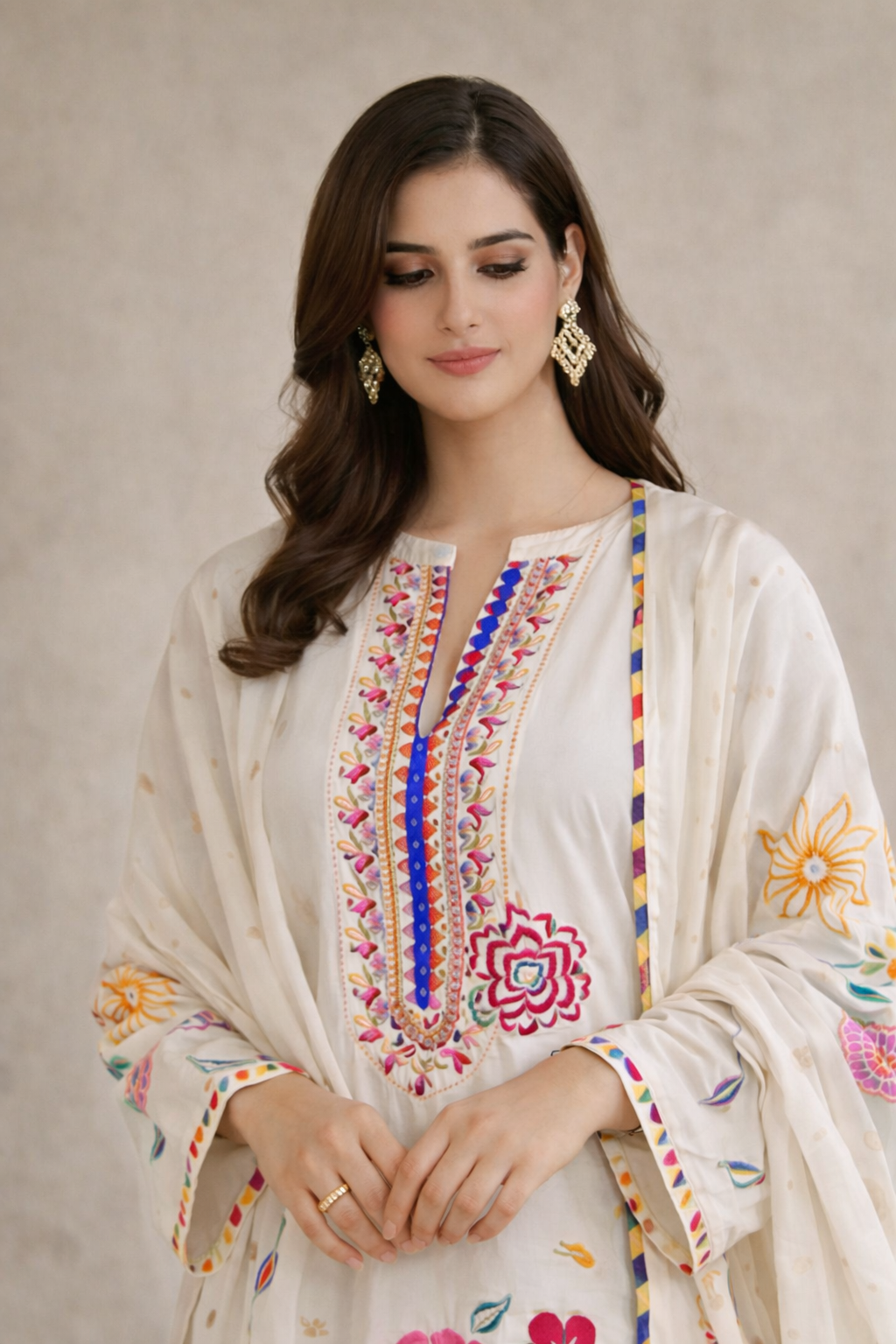 Woman wearing a white embroidered traditional outfit with colorful patterns on a neutral background