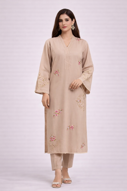 Woman wearing a beige embroidered kurta with pants on a white background